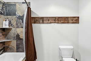 Full bathroom with shower / tub combo and toilet