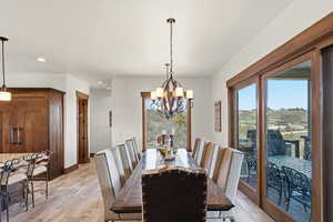 Dining space featuring healthy amount of natural light, light wood-type flooring, and suspended lighting