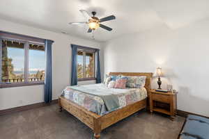 Bedroom with dark carpet and a ceiling fan