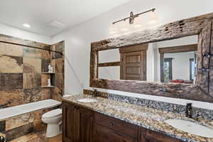 Bathroom with double vanity and tiled shower / bath