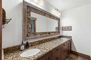 Bathroom with double vanity and stone tile flooring