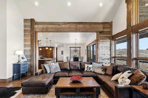 Living area featuring wood finished floors, a chandelier, and vaulted ceiling