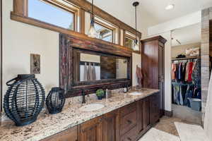 Bathroom with double vanity and a spacious closet