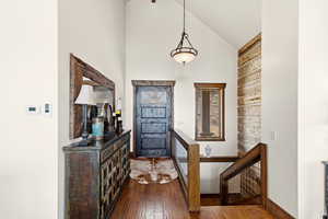 Foyer with lofted ceiling and dark wood finished floors