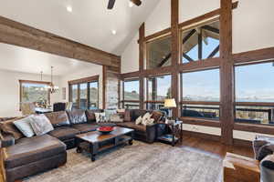 Living area with hardwood / wood-style floors, hanging lights, lofted ceiling, and ceiling fan