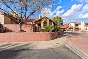 Mediterranean / spanish home with a fenced front yard, a chimney, stucco siding, and a tile roof
