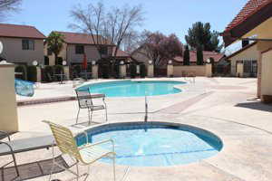 Community pool with a patio area and a hot tub