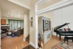 Sitting room with light wood-type flooring, recessed lighting, and a fireplace