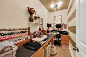 Office with light wood-style floors and built in study area