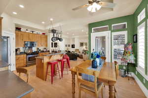 Dining room with light wood finished floors, ceiling fan, and recessed lighting