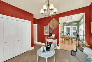 Sitting room featuring suspended lighting, a ceiling fan, and light tile patterned floors