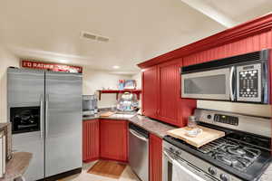 Kitchen with stainless steel appliances, recessed lighting, and open shelves