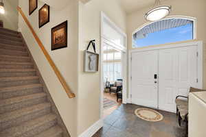 Foyer featuring stairway and stone tile flooring