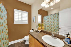Bathroom featuring vanity, curtained shower, a chandelier, and dark tile patterned floors