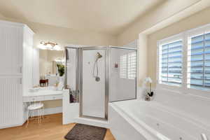 Bathroom with a shower stall, a whirlpool tub, vanity, and light wood finished floors