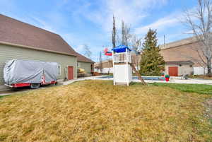View of grassy yard with a swimming pool and a patio