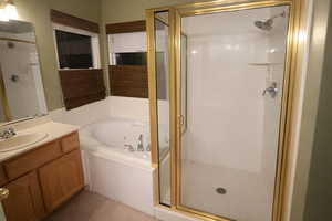 Full bath featuring vanity, a whirlpool tub, and a stall shower