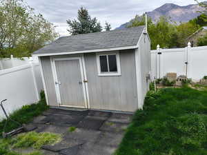 View of shed featuring a fenced backyard, a gate, and a mountain view