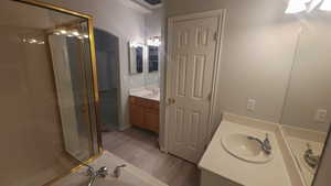 Bathroom with vanity, a stall shower, light wood-style floors, and a tub to relax in