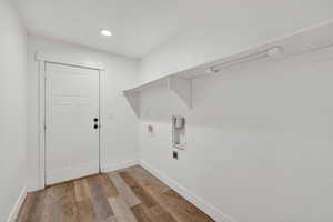 Laundry room with light wood finished floors, hookup for a washing machine, a textured ceiling, and recessed lighting