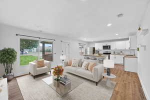 Living area with plenty of natural light, light wood-style flooring, and recessed lighting