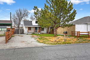 View of front facade featuring a porch and gravel driveway