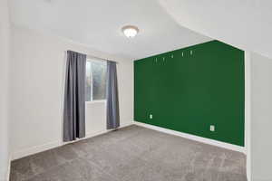 Unfurnished room featuring baseboards and light carpet