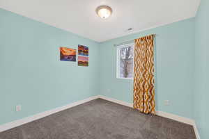 Carpeted spare room with baseboards and a textured ceiling