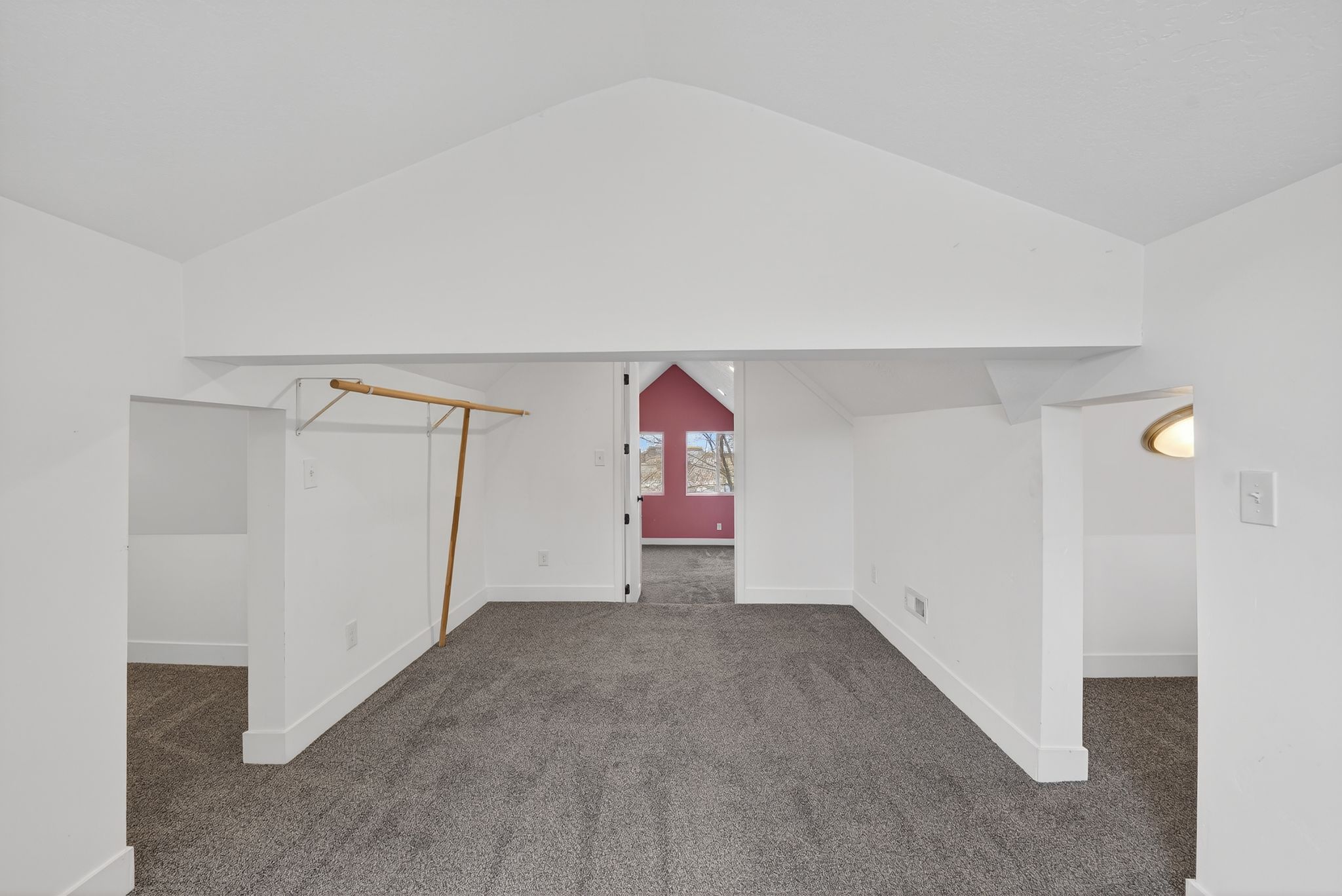 Additional living space with dark carpet and baseboards