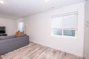 Living area featuring light wood finished floors and recessed lighting