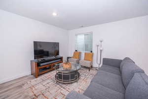 Living room with baseboards and light wood-style floors