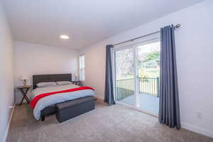 Carpeted bedroom featuring baseboards and access to exterior
