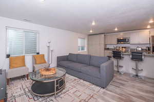 Living room featuring light wood-type flooring, recessed lighting, and a textured ceiling