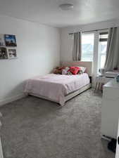 Bedroom with light carpet and a textured ceiling
