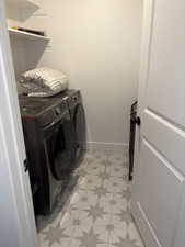 Laundry area featuring washing machine and dryer and light floors