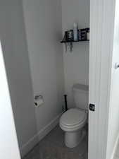 Bathroom with toilet and light tile patterned floors