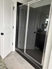Full bathroom with light tile patterned flooring and a stall shower