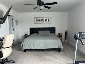 Bedroom with carpet floors, a textured ceiling, and ceiling fan