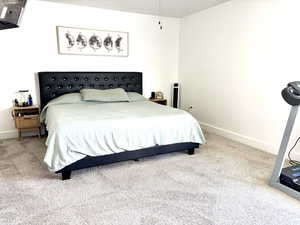 Bedroom with light colored carpet and baseboards