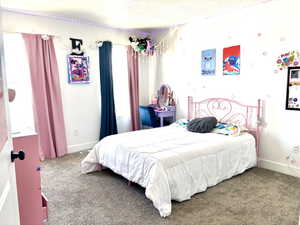 Carpeted bedroom with baseboards and a textured ceiling