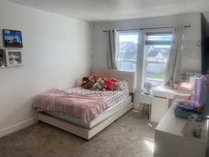 Carpeted bedroom with baseboards and a textured ceiling