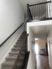 Stairway featuring a textured ceiling and wood finished floors