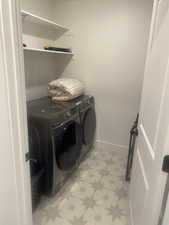 Laundry room with light flooring and independent washer and dryer