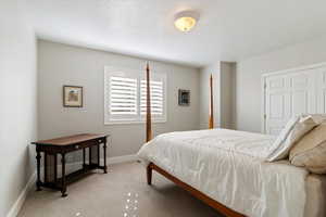Bedroom featuring light colored carpet and baseboards