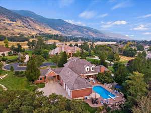 Aerial perspective of suburban area featuring a mountain backdrop and a pool