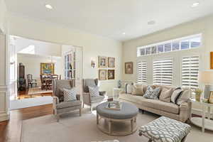 Living area featuring crown molding, wood finished floors, and hanging lights