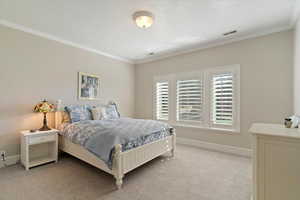 Bedroom featuring ornamental molding and light carpet