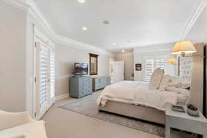 Bedroom featuring light carpet, crown molding, and recessed lighting
