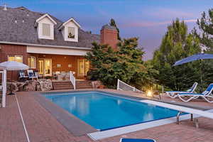 Swimming pool with a patio area and a diving board