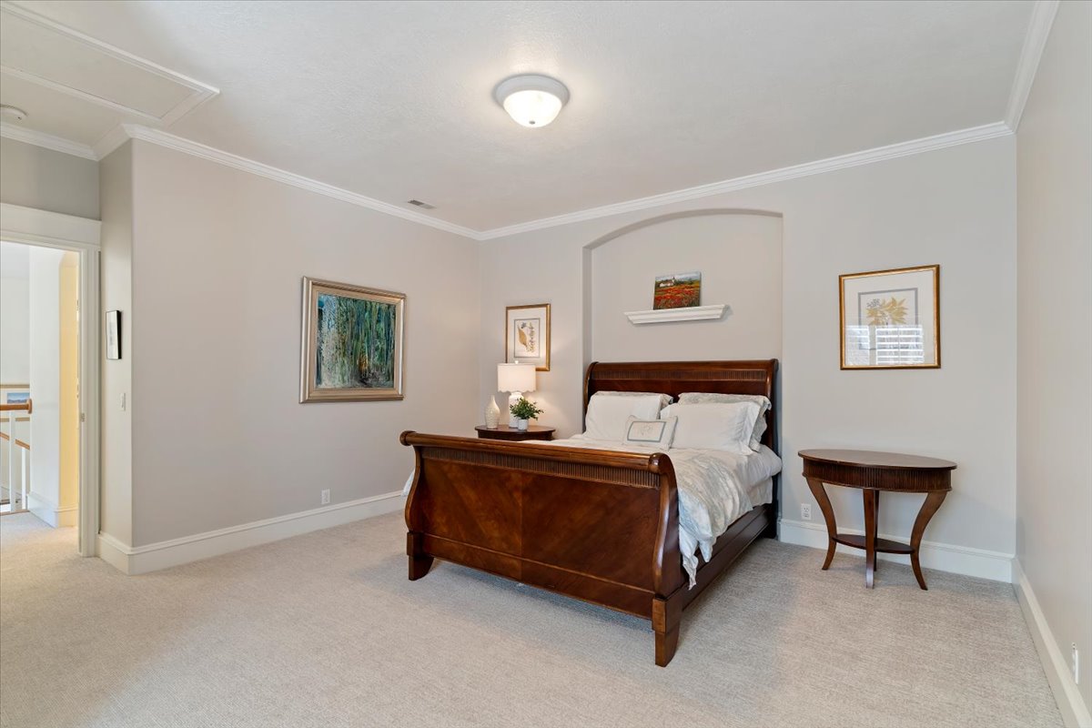 Bedroom featuring crown molding and light colored carpet